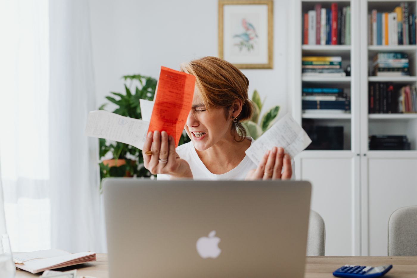 A business owner surrounded by scattered paperwork at her desk